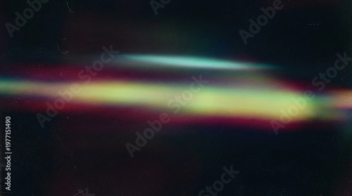 Colorful prismatic light streak with rainbow tones on dark background