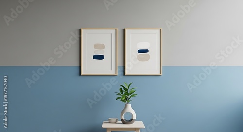 Two contemporary abstract minimalist framed art prints featuring stacked organic shapes in muted beige and deep navy blue tones hanging above a small table centerpiece.