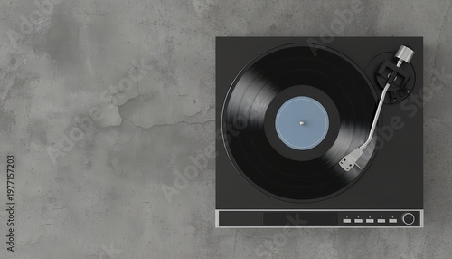 Top view of a black turntable with a vinyl record playing and tonearm positioned on the textured gray surface Its sleek design features a blue label on the record and control buttons