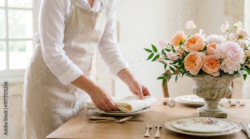 A catering staff member’s hands folding an ivory linen napkin Table concept emphasizes luxury dining, event decoration, romantic atmosphere, refined interior styling.