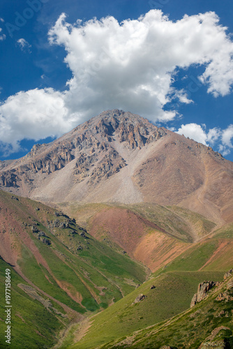 High altitude summer landscape of the Satpayev Peak massif with a picturesque sky and alpine meadows