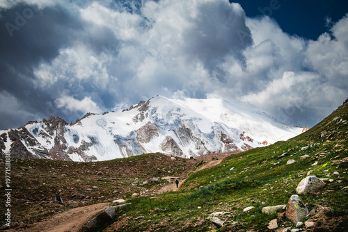 Majestic view of Molodezhny Glacier in Trans-Ili Alatau. Massive ice fields and snow-covered slopes under dramatic sky near Almaty. High altitude alpine landscape.