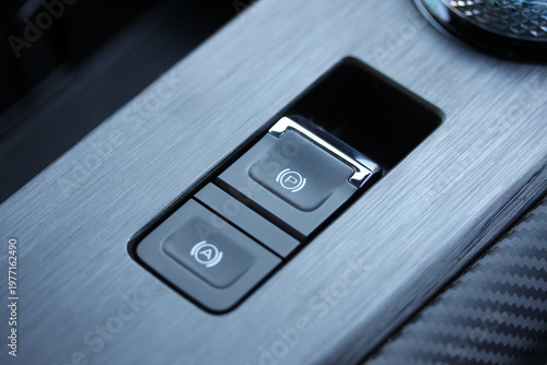 Close up of auto hold and park brake buttons in a modern luxury vehicle