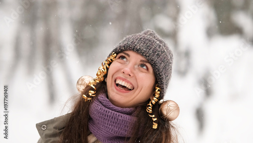 Photos A beautiful young woman in winter clothes is happily spending her free time in a snowy forest