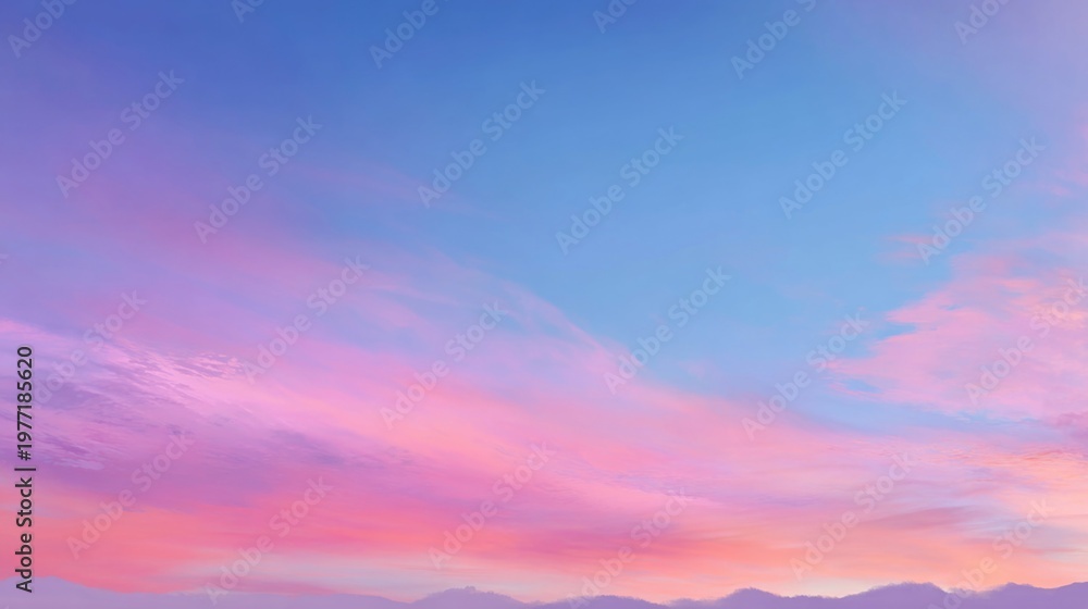 Obraz premium Tranquil Sunset Sky with Soft Pink and Blue Hues Over Mountain Landscape at Dusk with Calm Atmosphere