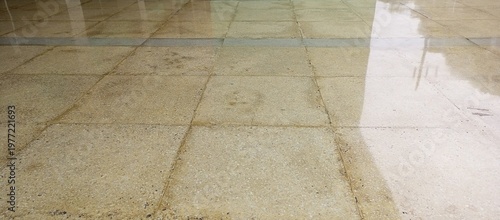 Wet terrazzo floor tiles with water reflection and perspective view