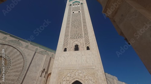 pan view of Hassan II Mosque against sky , Hassan II Mosque minaret looking up through arches - Hassan II Mosque minaret upward view through ornate arches Casablanca, Morocco