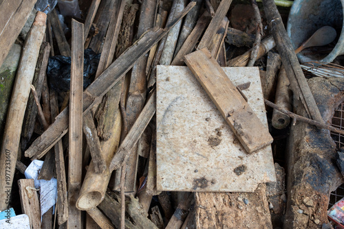 Pile of scrap wood and bamboo pieces on dirt ground