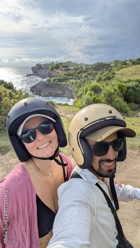 Friends couple riding motorbike through tropical countryside in Bali Asia, honeymoon adventure exploring farmland and remote roads, caucasian travelers enjoying journey on scooter, travel discovery