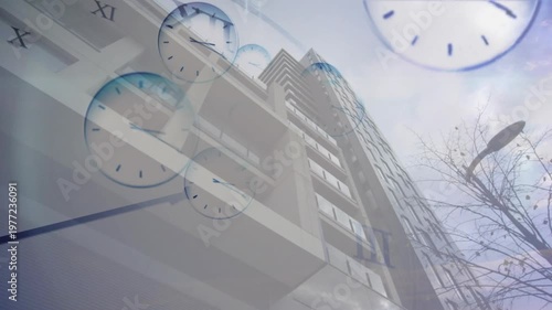 Showing tall building at street clock faces emerging showing time with bare branches and streetlamp