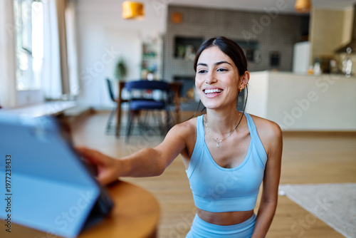 Free Download Portrait of a fit latina  girl young woman exercising practicing yoga or fitness watching online instructions tutorial on laptop at home - GFXLoad
