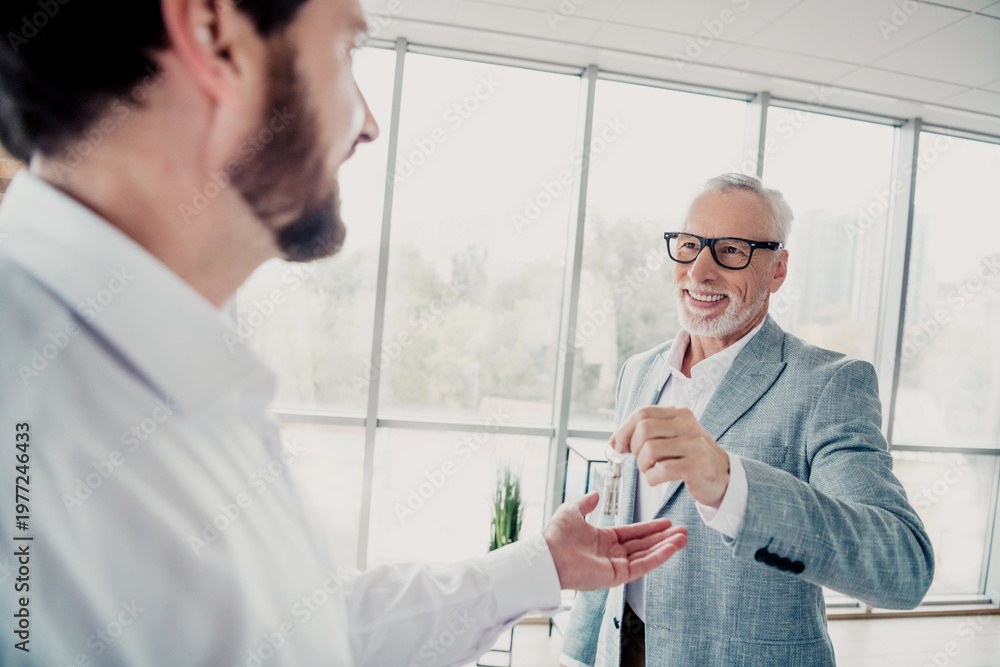 Fototapeta premium Business partners in a modern office exchange a small bottle during a friendly professional moment