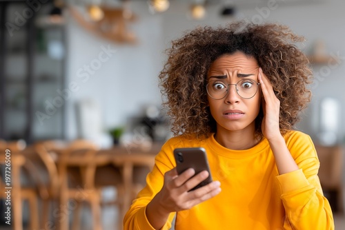 Shocked woman looking at smartphone with financial problem at home