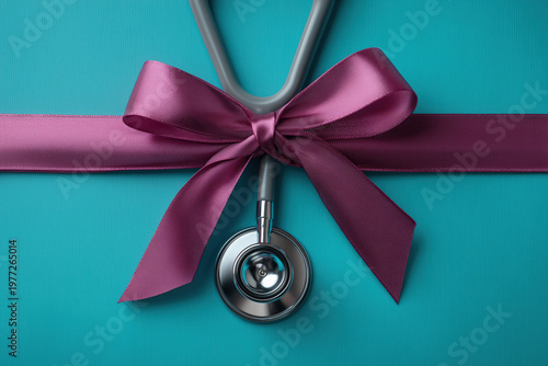 Stethoscope with purple ribbon bow on teal background for healthcare awareness