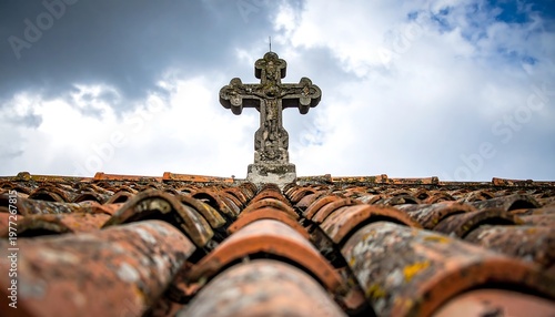 Ornate stone cross atop a tiled roof