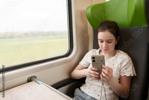 Girl using smartphone while traveling by train