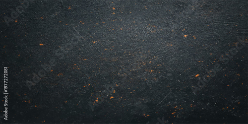 A closeup of a rough asphalt road texture creates an abstract black and white pattern with a dark bitumen surface and white paint lines covered in a light dusting of winter snow