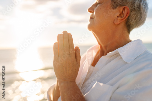 Fotografía A gray-haired woman enjoys the seascape at sunset