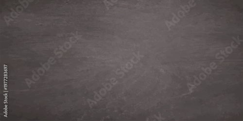 A dark grunge black chalkboard background with a rough textured stone surface and an aged vintage wall pattern creates a blank dirty blackboard backdrop