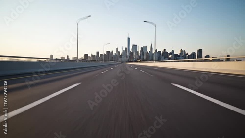 Highway leading towards a city skyline with skyscrapers and bright sky