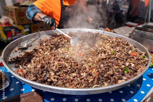 Street Food Vendor Cooking Chopped Doner Meat on Large Pan