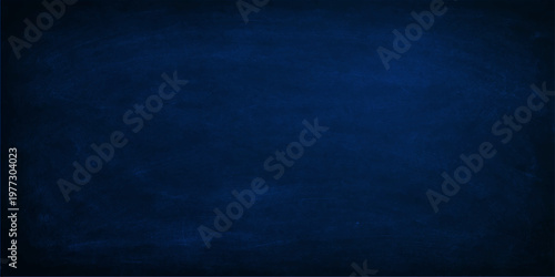 A dark blue grunge background with a textured chalk board surface and vintage denim fabric pattern creates a rough material wallpaper for a textile design backdrop