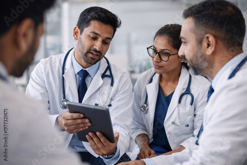 Doctors discussing patient case using tablet in hospital