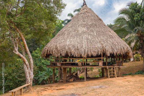 Foto Traditional raised stilt house with a conical thatched roof in an Embera indigen