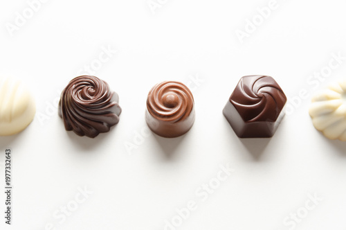 Assorted chocolate bonbons on white background. Chocolate day concept. Horizontal format with copy space. 
