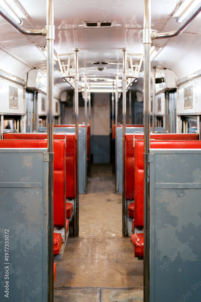 Fototapeta premium Retro tram interior with red seating and metal handrails