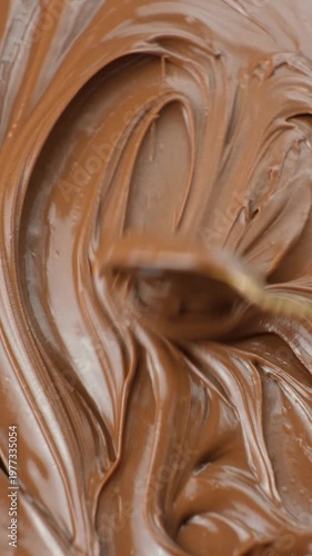 Macro close-up of glossy chocolate spread texture being stirred