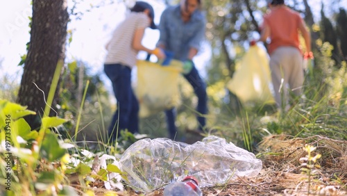 Foto Unrecognizable volunteers collecting plastic waste and trash in a park or forest