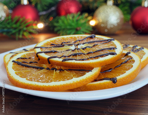 A white plate filled with neatly arranged orange slices, each drizzled with dark chocolate with a christmas garland background. Ai