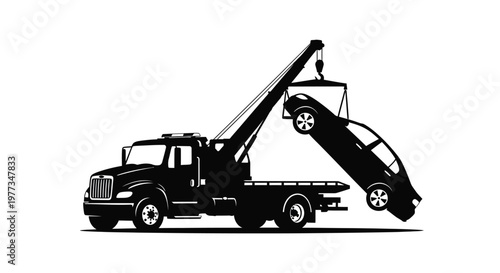 A black tow truck lifting a car with a dramatic silhouette