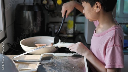 Child cooking food in a home kitchen using simple utensils. Suitable for family life, learning, and daily activity themes.