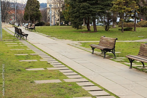 Autumn park, benches on the path