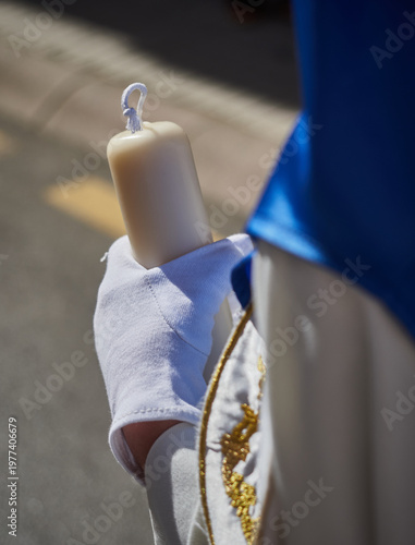 Detail penitent white holding a candle during Holy Week, Spain