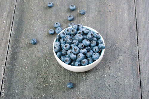 bilberry fruits at china bowl, on dark wood table