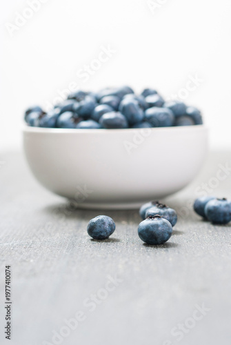 bilberry fruits at china bowl, on dark wood table