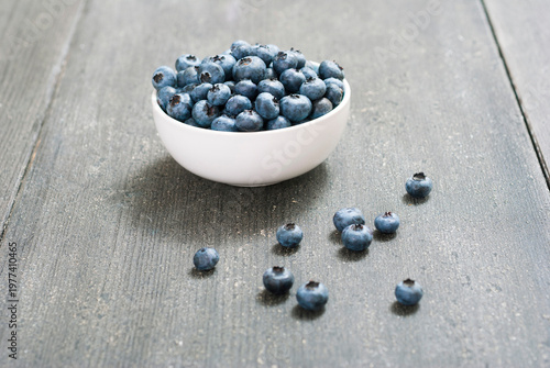 bilberry fruits at china bowl, on dark wood table