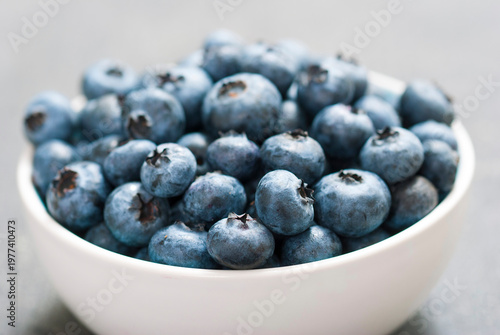 bilberry fruits at china bowl, on dark wood table