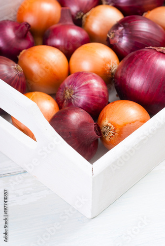 onions on white wood tray, wooden table background