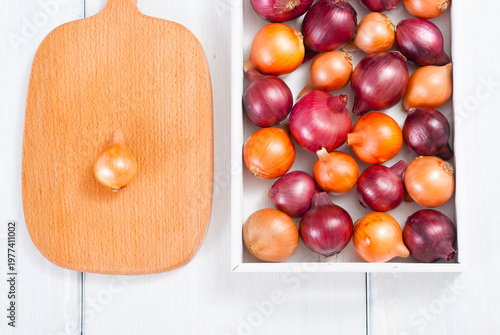 onions on white wood tray, wooden table background