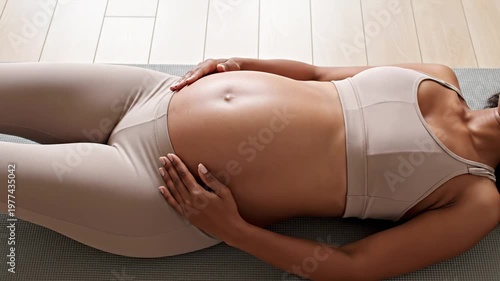 Pregnant Woman in Activewear Lying on Yoga Mat While Resting and Touching Her Belly