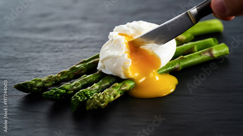 Poached egg with asparagus on slate plate with runny yolk
