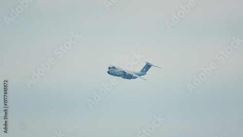 Strategic airlift mission featuring Airbus A400M Atlas soaring through the cloudy skies during a daytime operation
