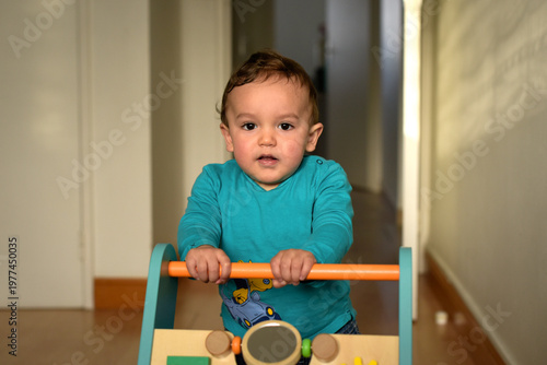 young child taking their first steps with a walker
