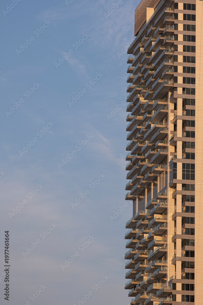 Fototapeta premium Modern skyscraper facade detail in Dubai. Close-up of glass windows and balconies of a luxury residential building, architectural pattern and contemporary urban design.