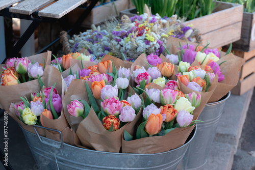 Colorful tulip bouquets in paper wrap displayed at street flower market