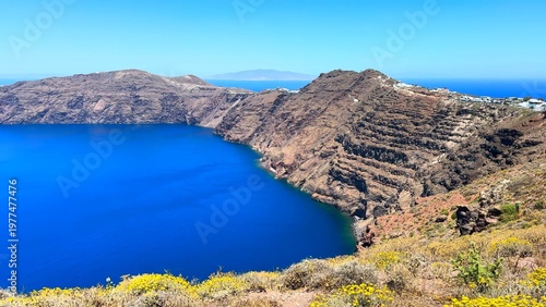 Volcanic cliffs of Santorini, Greece above the Aegean Sea with expansive blue horizon, featuring rugged coastal formations and iconic island panorama